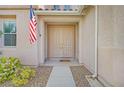 The double front door of this home is flanked by an American flag and flower bushes at 10409 Snowdon Flat Ct, Las Vegas, NV 89129
