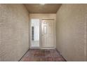 Welcoming entryway with neutral walls, brick flooring and sidelight window at 1043 Armillaria St, Henderson, NV 89011
