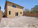 Large, sun-drenched backyard featuring a covered patio, minimal landscaping, and tall fencing at 10609 Sand Mountain Ave, Las Vegas, NV 89166