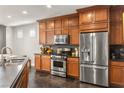 Well-equipped kitchen with stainless steel appliances, wood cabinets, and dark countertops at 11294 Corsica Mist Ave, Las Vegas, NV 89135