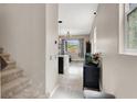Inviting hallway featuring tiled floors, a staircase, and modern lighting fixtures at 12426 Oregon Cherry Ave, Las Vegas, NV 89138