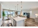 Open-concept kitchen with island seating flowing seamlessly into the dining and living areas at 12532 Blissful Sky St, Las Vegas, NV 89138