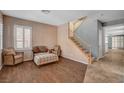 Cozy living room features wood floors, shuttered windows, and a staircase to the upper level of the home at 165 Calm Morning Ave, Henderson, NV 89002