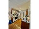 Efficient kitchen layout with white appliances, wood cabinets, and durable laminate flooring at 221 Mission Newport Ln # 205, Las Vegas, NV 89107