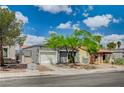 Charming single-story home featuring mature landscaping, a well-maintained lawn, and a two-car garage at 2377 Los Feliz St, Las Vegas, NV 89156