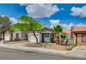 Charming single-story home featuring mature landscaping, a well-maintained lawn, and a two-car garage at 2377 Los Feliz St, Las Vegas, NV 89156