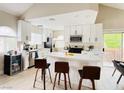 Bright kitchen with white cabinets, stainless steel appliances, a center island with seating, and sliding glass doors at 2925 Wigwam Pkwy # 724, Henderson, NV 89074
