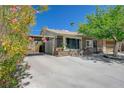 Cozy single-story home with a covered carport, two-car garage, and a blooming tree accentuating the facade at 3266 Mountain Spring Rd, Las Vegas, NV 89146