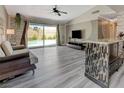 Bright living room featuring wood floors, ceiling fan, and sliding glass doors to the pool at 3266 Mountain Spring Rd, Las Vegas, NV 89146