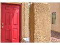 A close up of a vibrant red front door and textured stucco wall at 3568 Gloucester Gate St, Las Vegas, NV 89122