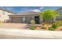 Charming single-story home featuring a three-car garage, desert landscaping, and a welcoming entrance at 3817 Grazing Gazelle Ave, North Las Vegas, NV 89084