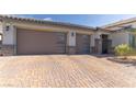 Three-car garage with stylish doors and stone accents, complemented by a paved driveway at 3817 Grazing Gazelle Ave, North Las Vegas, NV 89084