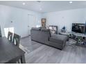 Open-concept living room with modern gray sofa, contemporary decor, and light gray flooring at 3934 Palos Verdes St, Las Vegas, NV 89119
