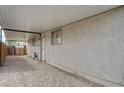 A carport of the home, offering covered parking or storage space, with gravel and a wall of the house at 4428 Ash Ave, Las Vegas, NV 89110
