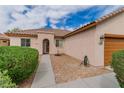Charming home exterior featuring a stucco facade, tiled roof, and drought-tolerant landscaping at 5319 Farley Feather Ct, North Las Vegas, NV 89031