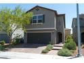 Charming two-story home features a front yard with desert landscaping and an attached two-car garage at 6631 Frosted Harvest Ave, Las Vegas, NV 89108