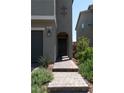 View of the house's front door with a short brick pathway and desert landscaping at 6631 Frosted Harvest Ave, Las Vegas, NV 89108