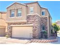 Two-story house with beige exterior, stone accents, and a two-car garage, front yard at 81 Sertata Ct, Henderson, NV 89074