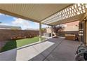 Charming covered patio with concrete flooring and artificial grass at 10617 Tuckermans Ave, Las Vegas, NV 89129
