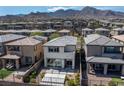 Rear exterior view of a two-story home with patio and desert landscaping with mountain views at 12524 Skylight View St, Las Vegas, NV 89138