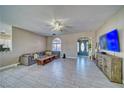 Well-lit living space with a ceiling fan, tile floors, and an inviting sectional sofa at 2171 Deadwood St, Pahrump, NV 89048