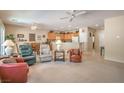 Spacious living room with neutral tones, carpet, ceiling fans, and adjacent dining and kitchen areas at 2539 Stardust Valley Dr, Henderson, NV 89044