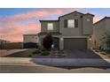 Charming two-story home with a well-maintained lawn, brick-paved driveway, and a warm-toned sunset in the background at 4630 Adonis Blue St, North Las Vegas, NV 89031