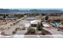 Wide shot of a single story home with a red tile roof, basketball court, metal outbuilding, and desert landscaping at 5315 N Fort Apache Rd, Las Vegas, NV 89149