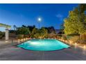Backyard pool with desert landscaping and ambient lighting offering a refreshing and serene outdoor space at 5858 Majestic Tide Ave, Las Vegas, NV 89131