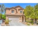 Inviting two-story home with an attached two-car garage and manicured landscaping at 6046 Bassio Ave, Las Vegas, NV 89141