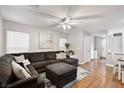 Spacious living room showcasing a sectional sofa, ceiling fan, and natural light from the bright windows at 6299 Oread Ave, Las Vegas, NV 89139