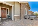 Inviting front porch featuring a seating area with a stone facade at 689 Moonstone Beach Pl, Henderson, NV 89011