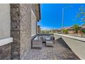 Cozy front porch featuring a seating area and textured stone accents at 689 Moonstone Beach Pl, Henderson, NV 89011