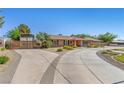 Wide driveway leads to a single-story home featuring desert landscaping and an RV cover at 7350 W Rome Blvd, Las Vegas, NV 89131