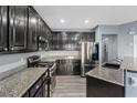 Well-equipped kitchen with granite countertops, dark wood cabinets and modern stainless steel appliances at 8566 Burning Bridge Ct, Las Vegas, NV 89131