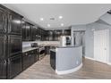 Modern kitchen featuring dark cabinetry, granite countertops, stainless steel appliances, and an island at 8566 Burning Bridge Ct, Las Vegas, NV 89131
