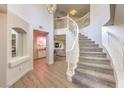 Grand foyer featuring a curved staircase, an open floor plan, and access to a bar area at 9124 Sapphire Ridge Ave, Las Vegas, NV 89129