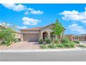 Attractive one-story home showcasing manicured desert landscaping, a tile roof, and a two-car garage at 9590 Smiley Creek St, Las Vegas, NV 89178