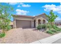 Stunning house with desert landscaping, a two-car garage, and an inviting, arched entryway at 9590 Smiley Creek St, Las Vegas, NV 89178