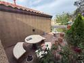 Outdoor patio area featuring stone benches, a table, fountain, and colorful potted plants at , North Las Vegas, NV 89031