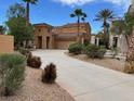 Elegant home featuring a long driveway, desert landscaping, and a charming stucco exterior at 1091 Casa Palermo Cir, Henderson, NV 89011