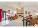 Inviting living room featuring a brick fireplace, sliding glass doors to the backyard and comfortable seating at 197 Ebb Tide Cir, Las Vegas, NV 89123