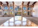 Grand living room with soaring ceilings, wooden beams, and expansive windows overlooking the pool at 42 Gulf Stream Ct, Las Vegas, NV 89113