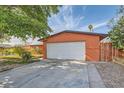 Single-story home with a driveway leading to an attached garage and mature trees at 5317 Holmby Ave, Las Vegas, NV 89146
