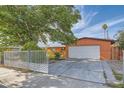 Single-story house features a driveway, mature trees, and a gated front yard at 5317 Holmby Ave, Las Vegas, NV 89146