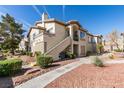 An exterior view showing well-manicured landscaping with condo's stucco and walkways at 5710 E Tropicana Ave # 2218, Las Vegas, NV 89122