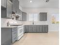 Bright, modern kitchen featuring gray cabinets, white quartz countertops, and stainless steel appliances at 60 Pecos St, Las Vegas, NV 89110