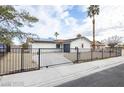 Charming single-story home with a gated front yard and solar panels, blending security with eco-friendly features at 6170 W University Ave, Las Vegas, NV 89103