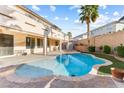 Inviting backyard featuring a sparkling pool, manicured landscaping, and covered patio at 623 Blue Snow River Ct, Henderson, NV 89002
