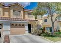 Inviting two-story townhome showcasing desert landscaping, attached garage and warm exterior tones at 6540 Angel Mountain Ave, Las Vegas, NV 89130